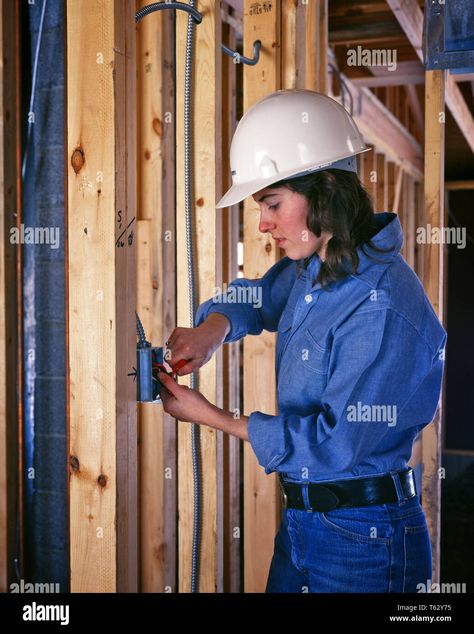 Download this stock image: 1970s YOUNG WOMAN ELECTRICIAN WEARING WHITE HARD HAT WORKING INSTALLING PLASTIC WALL SWITCH BOX IN BUILDING UNDER CONSTRUCTION - ks15244 VRE001 HARS LADIES PERSONS INSPIRATION PROFESSION CRAFT CONFIDENCE DENIM BRUNETTE BLUE COLLAR SKILL OCCUPATION SKILLS HARD HAT CAREERS LABOR RIGHTS IN OPPORTUNITY EMPLOYMENT OCCUPATIONS CONNECTION FRAMING OUTLET EMPLOYEE LIBERATION TRADE TRADES WOMEN'S ELECTRICIAN EQUALITY UNDER CONSTRUCTION YOUNG ADULT WOMAN CAUCASIAN ETHNICITY INSTA Electrician Outfit, Woman Electrician, Women Electrician, Female Electrician, Women In Construction, Building Under Construction, Labor Rights, Handy Man, Disco Era