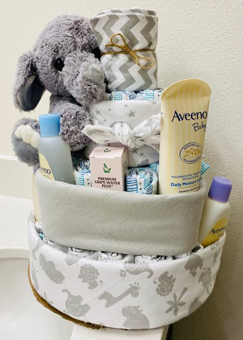 Baby boy diaper cake made from diapers, a paper towel roll, receiving blankets, baby toiletries, and a stuffed elephant 💙 Baby Boy Diaper Cake, Baby Toiletries, Stuffed Elephant, Baby Essentials Newborn, Diaper Cake Boy, Blankets Baby, Baby Shower Diaper Cake, Baby Equipment