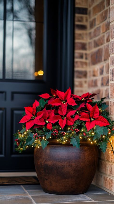 Large brown Christmas planter filled with red poinsettias, holly, and lights on an elegant porch, enhancing the festive Christmas Planter Ideas, Christmas Planter, Giant Christmas Ornaments, Outdoor Christmas Decor Ideas, Outdoor Christmas Planters, Outdoor Nativity Scene, Christmas Projector, Outdoor Nativity, Holiday Planter