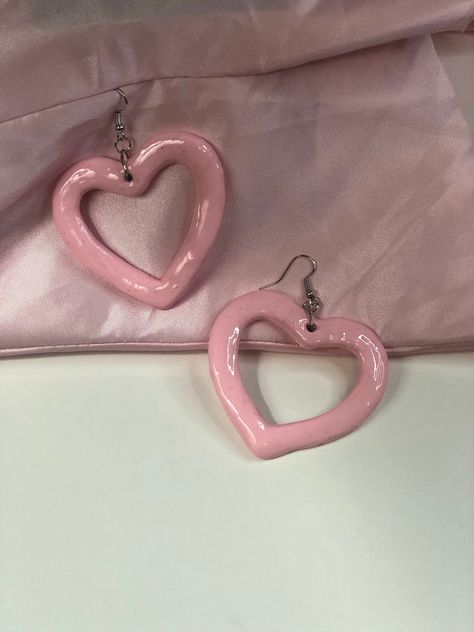 Heart-shaped dangle earrings made from clay. Pink Heart Earrings Aesthetic, Acrylic Laser Cut Earrings, Mini Ceramics, Heart Shape Earrings, Band Au, Trilogy Tour, Pink Heart Earrings, Halloween Idea, Diy Jewelry Unique