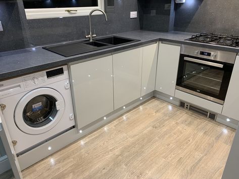 Light grey gloss doors with dark grey sparkle laminate worktops and backsplash. Integrated washing machine hidden behind matching decorative door. Integrated Washing Machine, Hidden Washing Machine, Laminate Worktop, Under Sink, Kitchen Diner, Backsplash, Laminate, Door Decorations, Diner