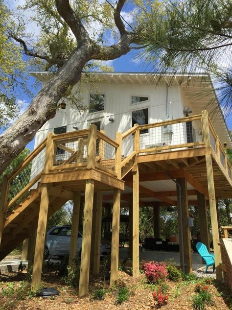 This 576 sq. ft. small house is designed by architect Bruce Lanier of Standard Creative. It has a 24′ by 24′ footprint and sits on 15′ tall foundation piers. When you go inside yo… Small Stilt House, Stilt Beach House, House Plans On Stilts, Home On Stilts, Stilt House Plans, Beach Tiny House, Small House Bliss, Tiny Beach House, Small Beach Houses