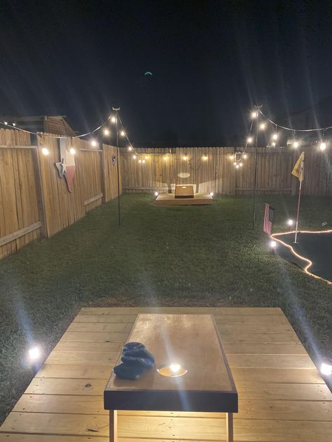 Backyard Diy Firepits, Cornhole Patio Ideas, Fire Pit And Picnic Table Area, Cornhole At Night, Back Yard Games Outdoor, Diy Camp Fire Pit, Outback Patio Ideas, Backyard Yard Game Area, Bilevel Backyard Ideas