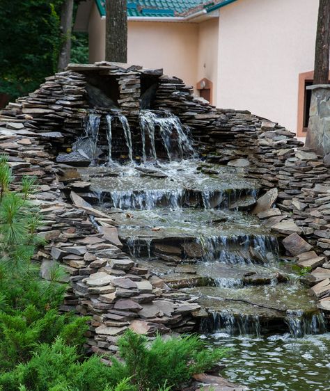 A large multi-level waterfall water feature made of loosely layered black slate stones. There was no concrete used to construct this and only relies on gravity and the weight of each piece of rock to hold them together. The flat slate stones used are perfect for creating a gentle water terrace. Water Terrace, Stone Water Features, Small Front Gardens, Garden Water Feature, Fountains Backyard, Garden Waterfall, Front Garden Design, Waterfall Wall, Pond Landscaping