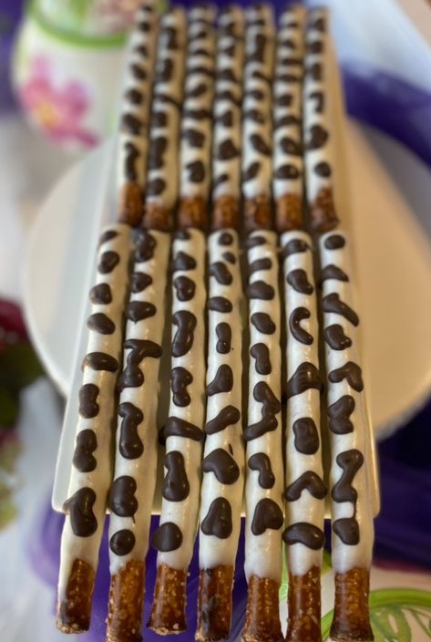 Pretzel rods, dipped in white chocolate and dark chocolate spots to look like cows! How To Make Cow Print Pretzel Rods, Cow Print Chocolate Covered Pretzels, Cow Chocolate Covered Oreos, Cow Print Pretzels, Cow Chocolate Covered Pretzels, Farm Pretzel Rods, Cow Pretzel Rods, Cow Print Food Ideas, Cow Print Pretzel Rods