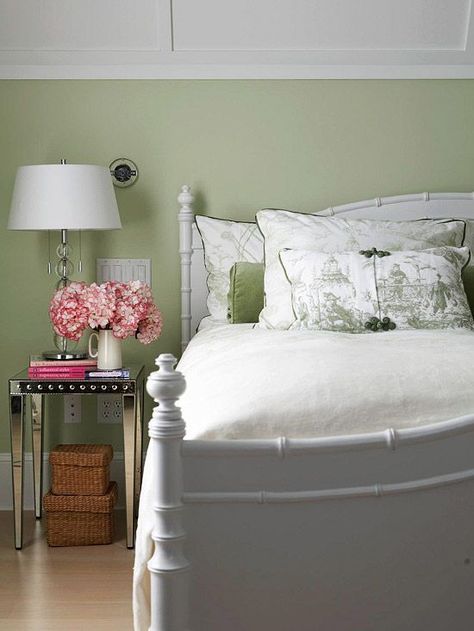 Restful Color Scheme    ale fern-green walls in this guest room provide a serene backdrop for the inviting faux-bamboo bed in bright white. Mirrored side tables add modern glamour, and green toile bedding brings in traditional style. Because of its restful and neutral quality, the light green makes the small touches of vivid pink -- the billowing hydrangeas and stack of books -- pop. Green And White Bedroom, Toile Bedding, Bamboo Bed, Summer Bedroom, Bedroom Updates, Room Photo, Cottage Life, Green Walls, Cottage Bedroom