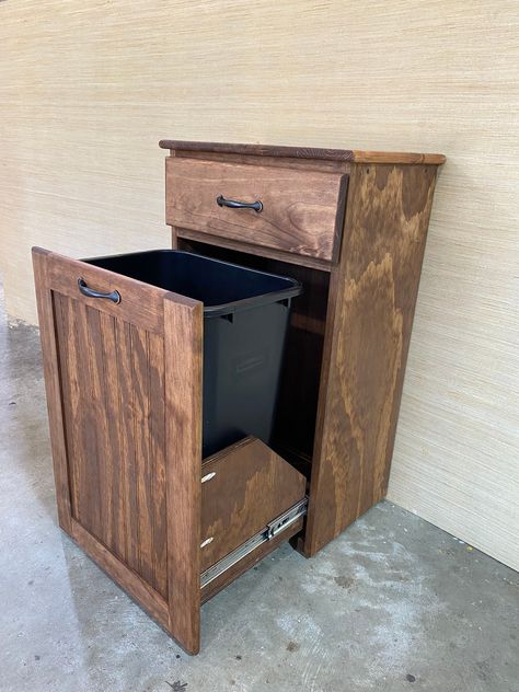 "This free standing trash can cabinet features a pull out design.  Both drawers have roller bearing drawer guides for smooth operation.   The wastebasket drawer has two casters that support the drawer when opened.   cabinet must be placed on smooth surface for casters to operate properly Cabinet also has 4 adjustable legs to ensure proper operation without any wobble, even if the floor isn't perfectly level.     The top drawer is 3\" deep.  Plastic wastebasket is included.  It is a 10.38 gal can Pull Out Trash Can Cabinet, Yard Tool Storage, Wood Trash Can, Can Cabinet, Pull Out Trash Cans, Trash Can Cabinet, Kitchen Trash Cans, Trash Bins, Adjustable Legs