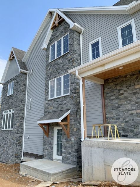 gray stone with wood tone accents Grey Siding House, Stone Front House, Grey Siding, Gray House Exterior, Dining Room Fireplace, Black Wall Lights, Exterior House Color, Floor Trim, Exterior Renovation