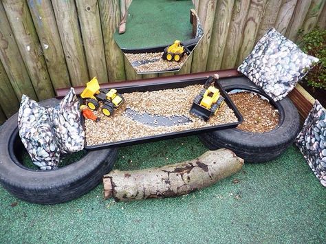 Eyfs small world outside construction area. Very easy to make using two tyres a garden planting tray, gravel and a couple of diggers. The cushions are wipe able pvc great for using outside. Small Eyfs Outdoor Area, Small World Garden Ideas Eyfs, Eyfs Garden, Outside Small World Area Eyfs, Eyfs Construction Area Outdoor Play, Outside Area Eyfs, Outdoor Construction Area Eyfs, Den Building Eyfs Outdoor Play, Eyfs Outdoor Area On A Budget