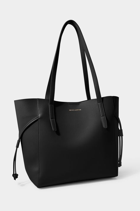 Katie Loxton s Ashley Tote Bag - a true must-have in every trendsetter s wardrobe. Designed to complement and enhance your daily routine, with a spacious interior that is laptop and iPad friendly, it s perfect for work, travel or leisure. The internal slip pocket provides added convenience, allowing you to keep your essentials organised and secure. The vegan leather material and gold-tone hardware add a touch of sophistication to your look, while the handle threading detail is completely unique