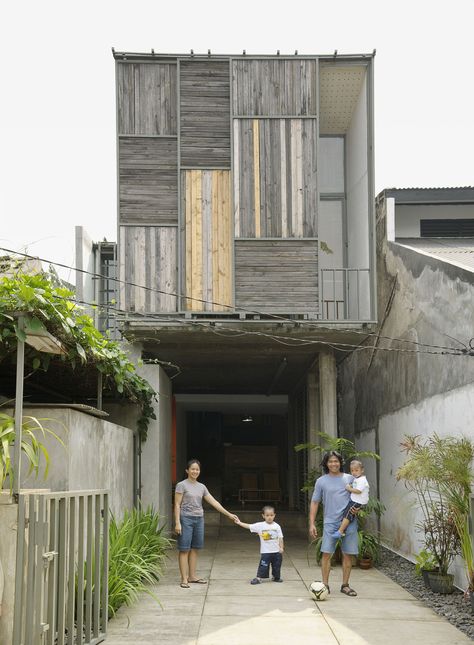 The family poses in the driveway out front of the house. The sliding panels on the facade allow a peek into the balcony just inside. Indonesian House, Modern Tropical House, Eksterior Modern, Narrow House, Tropical House, Modern Windows, Modern Tropical, Design Exterior, City Design