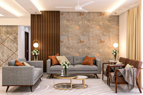 The grey textured fabric used in the wooden-framed sofa set with brown cushions adds a contrast to the room. Two brown accent chairs on the side complement the pale grey rug. The textured wall with a tint of gold and side wooden panelling enhances the look. A round nesting table with black and white marble table top and gold framework matches well with the overall interior. Living Area Wallpaper, Living Room Indian, Wallpaper House Design, Wooden Panelling, Drawing Room Interior Design, Living Room Wall Color, Latest Living Room Designs, Drawing Room Interior, Gold Living Room