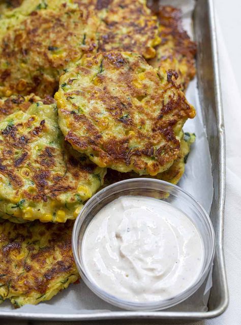 Zucchini Fritters are an appetizer made with zucchini and corn, fried to a crispy golden brown and dipped in a homemade seasoned sour cream. Corn Fried, Zucchini Corn Fritters, Baked Zucchini Fritters, Seasoned Sour Cream, Zucchini Fritters Recipe, Zucchini Corn, Grated Zucchini, Corn Fritters, Zucchini Fritters