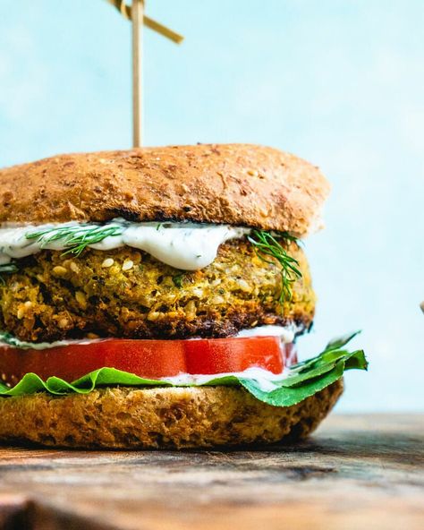 This insanely good falafel burger is easy to make and bursting with Mediterranean flavor! Smother in sauce for an epic vegetarian or vegan dinner. This healthy dinner recipe takes 45 minutes or less to cook and is perfect for those warm summer evenings. #vegan #vegetarian #falafel #veggieburger #burger #recipe Falafel Burger, Falafel Burgers, Best Veggie Burger, Cucumber Sauce, A Couple Cooks, Veggie Burgers Recipe, Homemade Tzatziki, Baked Avocado, Vegetarian Cookbook