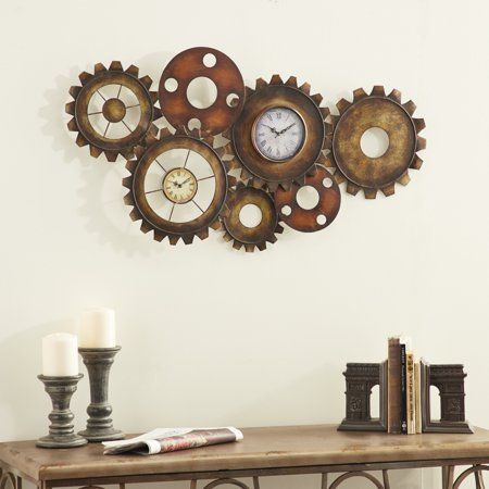 Boasting vintage industrial style, this extra large wall clock with 2 clock faces features metal gears with brushed gold, brown, and rust-colored finishes. The various-sized gears are layered over each other for a dimensional mechanical look, creating a long, horizontal metal clock shape. Two of the gears have clock faces, separately run on AA batteries each, so you can have 2 time zones displayed. Each face has a distressed antique finish with stylish Roman numerals. Extra Large Wall Clock, Industrial Gears, Industrial Clock Wall, Gear Wall Clock, Steampunk Wall, Clock Painting, Gear Clock, Wall Clocks Living Room, White Clocks