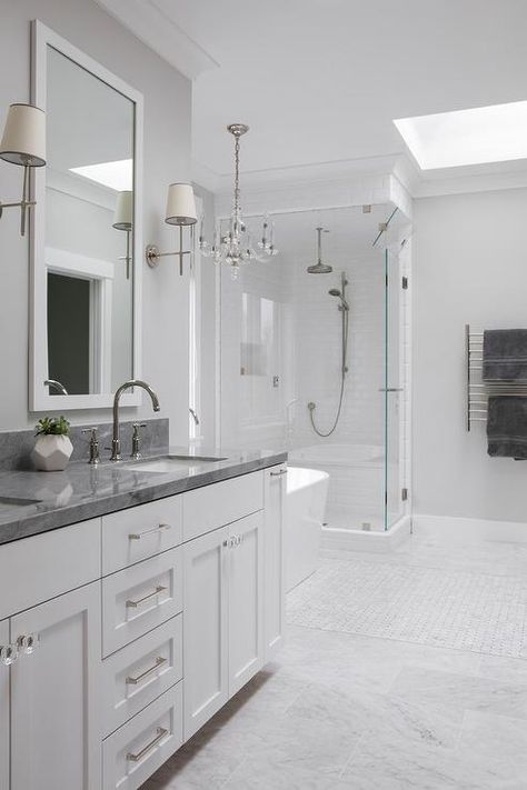 Luxurious and spacious, this white and gray master bathroom features gray polished marble countertops and white shaker cabinets with mixed hardware. White Granite Bathroom, Gray Marble Countertops, Grey Marble Bathroom, Granite Bathroom Countertops, Granite Bathroom, Marble Tile Bathroom, Dark Countertops, Countertop Ideas, White Bathroom Cabinets