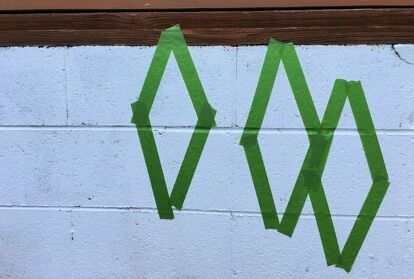 A cinder block wall does not have to be plain or an eyesore. Just grab some paint and a stencil and turn it into a feature! Our deck was built on a cinder block foundation, which is right by the swimming pool. I was tired of it looking unfinished, so I decided to paint it white, then added a pop of color with a fun design. See how I transformed this wall in one afternoon! I had painted the wall several years ago, but it was in need of a fresh coat of paint. After pressure washing the… Backyard Wall Murals Cinder Blocks, Mural On Cinder Block Wall, Paint Cinder Block Wall, Cinder Block Foundation, Backyard Wall, Block Foundation, Accent Wall Entryway, Hallway Gallery Wall, Breeze Block Wall