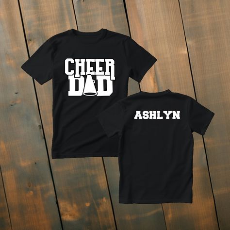 Custom Cheer Dad Shirt Make a statement of support with our custom cheer dad t-shirts! Available in various colors and sizes, these shirts are designed to be a perfect fit for any cheer dad. Personalize it with their name to make it truly one-of-a-kind. Wear it to cheer events, practices, or simply around town, and showcase your love and pride as a cheer dad! *Deets* *This custom shirt is handmade with professional vinyl. *Our shirts are unisex and are true to size! *In the photo's you will be able to see the custom options in regards to color that you may choose from. *We use 100% cotton shirts. The glitter material does not wash off and will last through multiple washes.  *If your shirt color is out of stock we will contact you as soon as possible to see if you would like to change shirt Cheer Dad Shirt Ideas, Cheer Dad Shirt, Cheerleading Picture Poses, Cheer Dad Shirts, Varsity Cheer, Spirit Gear, Cheerleading Pictures, Dad Tshirt, Dad Shirts