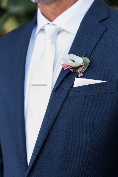 Groom with White Anemone and Pink Blossom Ribbon Wrapped Boutonniere, White Silk Tie, and Navy Suit White Tuxedo Wedding, Boutonniere White, Groom Blue Suit, Groomsmen Tie, White Boutonniere, Wedding Tux, Groomsmen Ties, White Anemone, Groom Ties