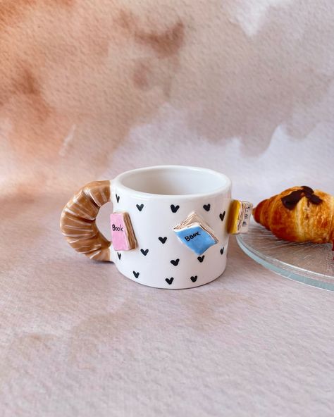 Start your mornings with the perfect blend of coffee and books! 📚☕ Our ceramic mug with book details and a croissant handle is a must-have for book lovers. #etsy #booklover #bookish #ceramicgift #BookLovers #Handmade #CoffeeTime #UniqueDesign Book Pottery, Cute Croissant, Book Ceramic, Croissant Coffee, Library Bookshelf, Book Mug, Ceramics Pottery Bowls, Ceramic Art Sculpture, Ceramic Products