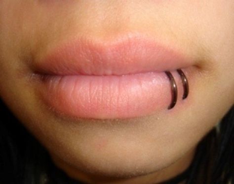 A double piercing with rings near the corner of the lower lip is called a spider bite piercing. Lower Lip Piercing, Spiderbite Piercings, Piercings Bonitos, Lip Piercing Ring, Snake Bite Piercing, Spider Bite Piercing, Spider Bites, Cool Piercings, Labret Piercing