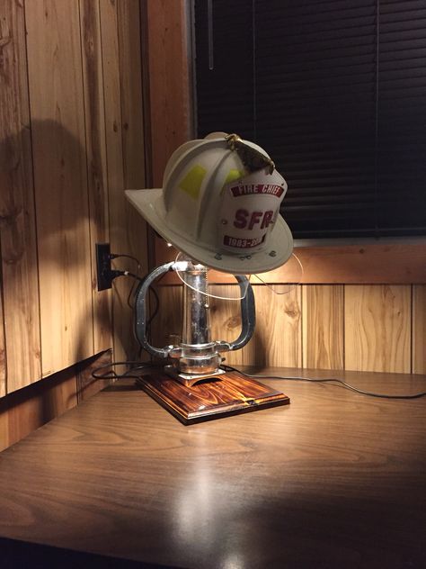 Fire helmet display with lamp Firefighter Display Ideas, Firefighter Room Ideas, Firefighter Helmet Display, Fire Chief Office Ideas, Diy Firefighter Decor, Firefighter Room Man Caves, Fire Helmet Display, Chin Length Layered Hair, Fire Hose Projects