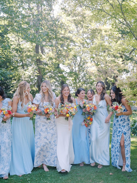 Bride with bridesmaids wearing blue solid and blue floral bridesmaids dresses for a coastal wedding Revelry Blue Bridesmaid Dresses, Black Tie Wedding Blue Bridesmaids, Blue Floral Dress Bridesmaid, Blue And White Wedding Bridesmaids, Spring Bridal Party Colors, Periwinkle Bridesmaids Dresses, Mismatch Blue Bridesmaids, Mismatched Blue Bridesmaids, Blue Mixed Bridesmaid Dresses