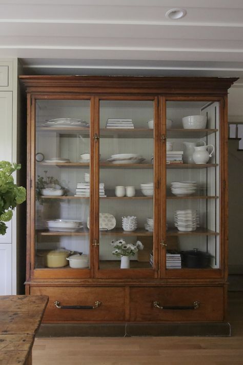 Beautiful antique kitchen cabinet furniture with glass panels. Collection of ceramic pottery. Farrow and Ball kitchen cabinets in Old White. Antique table island.