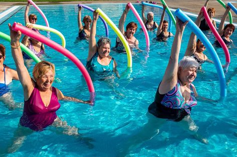 Action portrait of senior aqua gym class. Elderly ladies exercising together with foam noodles in outdoor swimming pool. Action Portrait, Foam Noodles, Showgirl Costume, Gym Photography, Pool Workout, Exercise Physiology, Water Aerobics, Pool Noodle, Gym Classes