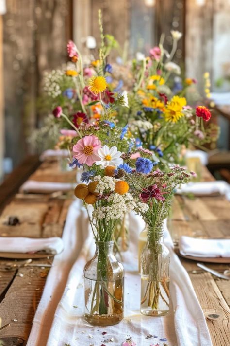 Fruit And Flower Table Decor, Wildflower Long Table Wedding, Colorful Wild Flower Wedding, Wild Flower Backyard Wedding, Summer Garden Table Setting, Wedding Table Decorations Wild Flowers, Boho Wildflower Wedding Table Decor, Wine Bottle Flower Arrangements Wedding, Wildflower Table Scape