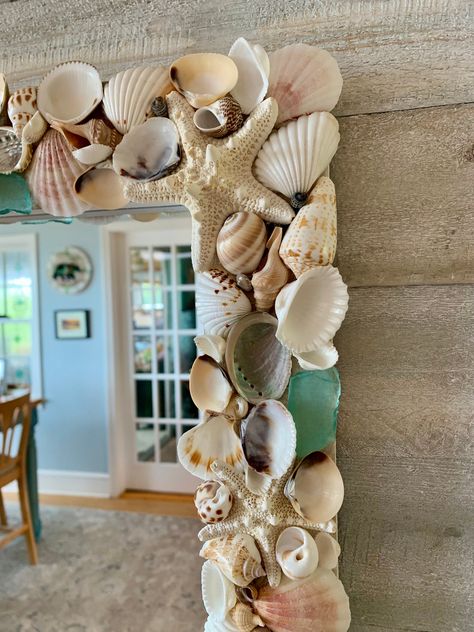 This best-selling, beautifully handcrafted seashell mirror is packed with a variety of seashells, armored starfish, pearlized shells, scallop shells, and aqua blue sea glass.  The seashell bed is designed on a rectangle white washed wood frame.  Mirror measures 19" x 24" All sea shells are securely attached using a high quality glue.    This seashell mirror wall decor can be hung vertically or horizontally, and the hardware is attached and ready to hang.  This mirror with seashell frame is made Seashells Mirror Frame, Frame Shells Diy, Seashell Mirror Frame, Broken Shells Ideas, She’ll Mirror, Seashell Mirror Diy, Mirror Craft Ideas, Shell Mirror Frame, Shell Mirror Diy