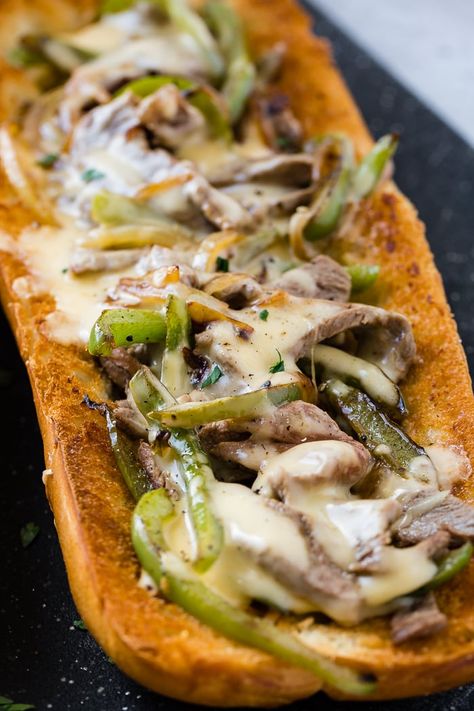 a french bread sliced open and filled with peppers, onions, steak and cheese sauce to make an easy philly cheesesteak recipe! French Bread Philly Cheese Steak, Cheese Sauce For Philly Cheese Steak, Philly Cheesesteak Sauce, Cheesesteak Sauce, Philly Cheese Steak Sauce, Steak Sandwich Sauce, Cheesesteak Bread, Special Sandwiches, Sweet Basil Recipes