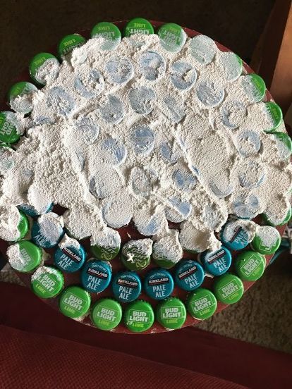 Makeover a table with saved beer caps, some glue and grout to give it a new look! #diy #diyhomedecor #table #sidetable Beer Cap Design, Crafts With Beer Bottle Caps, Bottle Cap Furniture, Bottle Cap Table Top Diy, Beer Caps Crafts, Bottle Cap Art Diy, Diy Beer Bottle Cap Crafts, Bottle Cap Table Top, Beer Caps Diy