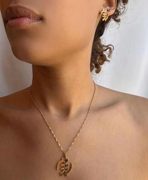 This stunning necklace and stud earrings set features the Gye Nyame symbol, an ancient Adinkra symbol from Ghana that represents the supremacy of God. The necklace pendant and earrings are carefully crafted from high-quality materials and suspended from delicate chain #Africa #Africaculture #Jewelry Gye Nyame, Symbol Jewelry, African Symbols, Adinkra Symbols, Symbol Necklace, Symbolic Jewelry, Delicate Chain, Stunning Necklace, Stud Earrings Set