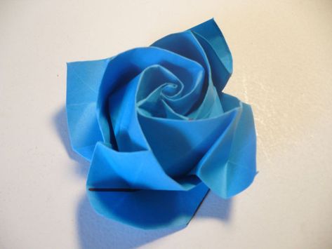 Make a wonderful, romantically beautiful paper flower project with this tutorial for how to make a paper rose. This Beautiful Blue Origami Rose is a stunning and practical origami project. Make this origami project as a lovely gift for an anniversary or as a pretty home decor piece for your friends. You will learn how to make paper flowers and everyone will certainly cherish your thoughtful gift. Blue roses connote regal majesty and splendor. So, if you have someone if your life that you want to Easy Origami Rose, Diy Origami Home Decor, Origami Home Decor, Rose Step By Step, Romantic Gifts For Girlfriend, Origami Star Box, Tutorial Origami, Origami Ball, Second Wedding Anniversary