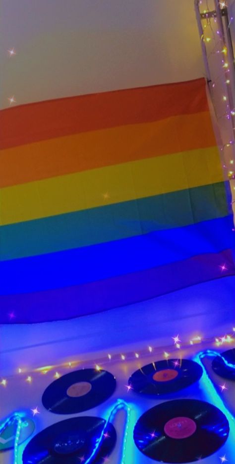 Vinyl records, neon lights, pride flag, fairy lights Pride Flag In Room Aesthetic, Pride Flag Bedroom, Pride Flag Room Decor, Pride Flags In Bedrooms, Trans Flag On Wall, Indie Room Ideas, Lgbtq Tapestry, Academia Clothing, Trans Pride Flag