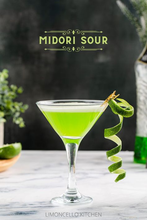 Side view of green Midori sour in a martini glass with a curly lime peel garnish, and a bottle of Midori in the background. Midori Sour, Unique Cocktail Recipes, Irish Drinks, Lime Peel, Cocktail Garnish, Sweet Tart, Festive Drinks, Summer Afternoon, Three Ingredient