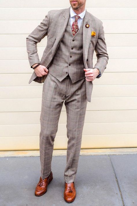 A three piece tan suit like this is the perfect groom attire for any wedding. A plaid tan suit can also be worn as a business casual suit in the office.If you would like a suit like this custom made for you, book an appointment online with us at Giorgenti New York! Plaid Wedding Suit Groom Attire, Brown Plaid Groom Suit, Groom Plaid Suit, Tan Plaid Suit, Brown Suit Wedding, Tan Suit Wedding, Fall Wedding Suits, Plaid Tuxedo, Plaid Wedding