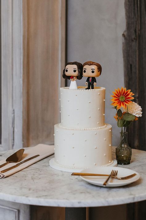 Two Tiered Wedding Cake with Custom Funko Pop Cake Topper  | A simple yet elegant two-tiered white wedding cake, topped with cute Funko Pop bride and groom figurines. Book Katarina to capture your timeless wedding photography or candid wedding photos at katarinacelinephotography.com! Funko Pop Wedding Cake, Funko Cake Topper, Funko Pop Cake Topper, Wedding Cake With Bride And Groom Topper, Funko Pop Wedding Cake Topper, Funko Pop Cake, Superhero Wedding Cake, Wedding Cake Simple Elegant, Wedding Cake Topper Figurines