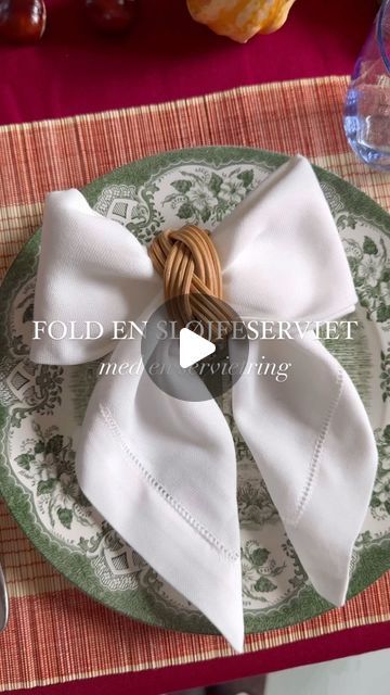 Langkilde & Søn - flag, duge og servietter on Instagram: "Sådan folder du nemt en flot sløjfeserviet med en servietring. 🎀 Husk at gemme opslaget.🏷️  Sådan gør du: 1) Fold din serviet en gang på midten fra bund til top. 2) Fold nu spidsen ned og fold servietten et par gange. 3) Tag den ene side og fold skråt nedad ind over midten. Gentag med den anden side.  4) Før den ene side af servietten igennem servietringen ind til midten.  5) Ret siderne ud. Du har nu en fin sløjfe.🎀  #langkildeogsøn #flagfabrik #danskdesign #danishdesign #slowdesign #servietfoldning #servietfoldningsvideoer #servietsløjfe #sløjfeserviet #tablescape #tablesettingdecoration #borddækning #borddækninginspiration #efterårsbord #fallfeels #falltabledecor #falltablescape #efterårsborddækning #napkinfolding" Napkin Silverware Folding Ideas, Folding Cloth Napkins Step By Step, New Year’s Eve Napkin Fold, Wrapping Utensils In Napkins Party Ideas, How To Fold Linen Napkins, How To Fold Napkins With Silverware, Easy Napkin Folding Step By Step, Christmas Serviette Folding, Fall Napkin Folding Ideas