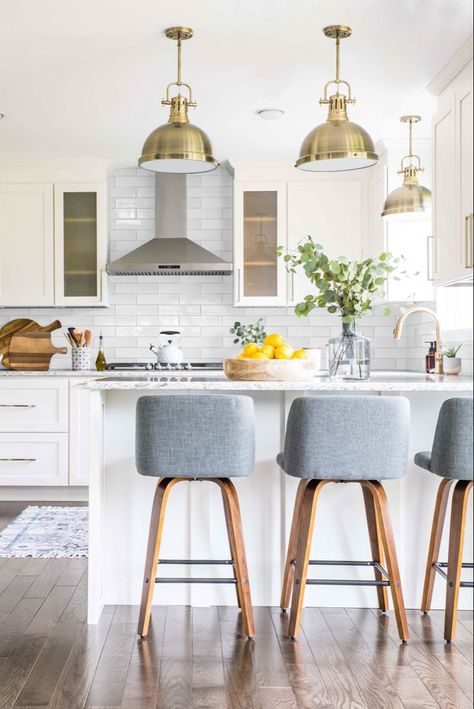 A white kitchen is timeless. The elongated subway tile in this kitchen gives this timeless kitchen a flare of the current. Mix metals brass pendant lights, brass sink faucet, polished nickel cabinet hardware. G Shaped Kitchen, Kitchen With Peninsula, Kitchen Peninsula, Shaker Style Cabinets, U Shaped Kitchen, White Backsplash, White Brass, Kitchen Stories, Gorgeous Kitchens