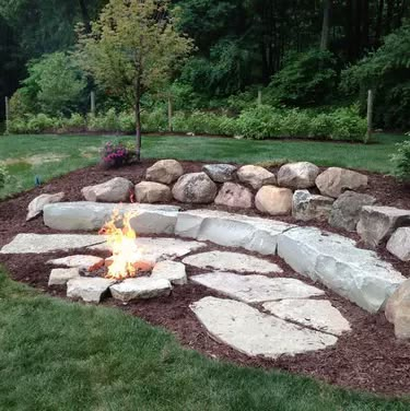 Backyard Fire Pit Ideas | Hunker Fire Pit With Rocks, Outdoor Fire Pit Area, Sunken Fire Pits, Backyard Fire Pit, Fire Pit Ideas, Fire Pit Landscaping, Sloped Backyard, Cool Fire Pits, Stone Fire Pit