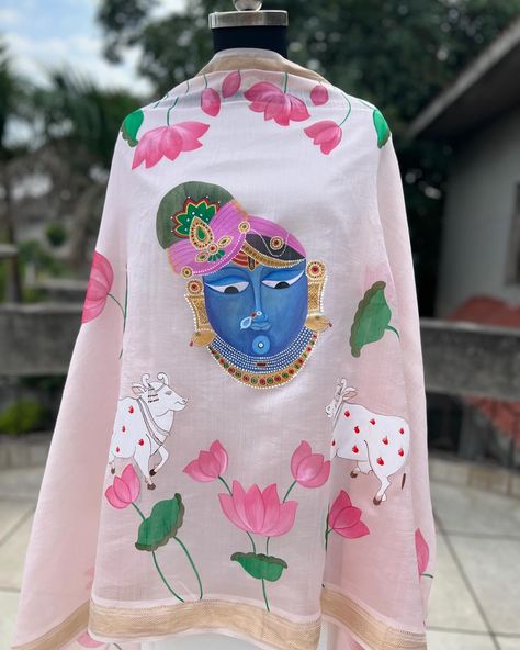 Pichwai 🪷 Embracing the grace of Pichwai art, this hand painted dupatta is a canvas of heritage and style. Shrinathji and lotus florals hand painted on a pastel pink pure maheshwari dupatta. Pair it up with a plain suit to create a stunning contrast and add an artistic touch to your outfit. The simplicity of the suit will allow the intricacy of the hand painted dupatta to stand out, making it a unique and elegant choice for any occasion. Shop now @inaayatbyaastha DM or comment for more de... Handpainted Dupattas, Painted Dupatta, Pichwai Art, Plain Suit, Tee Ideas, Pichwai Paintings, The Grace, The Hand, Your Outfit