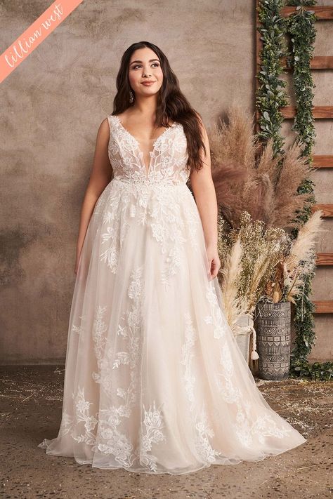 Feel light and romantic in this plus size A-line bridal dress. The illusion bodice features a plunging V-neckline and a V-back. It's adorned with sequined lace appliqués that float down the airy tulle skirt. For a more modest look, this style is also available with the front bodice lined to the side illusion insets.