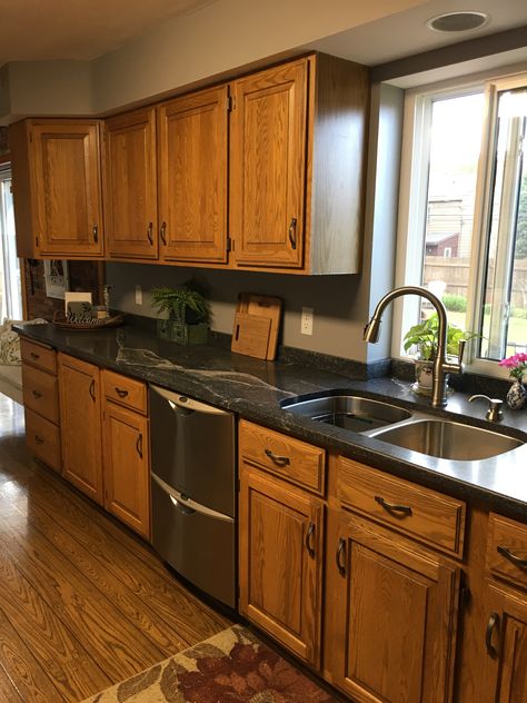 Black Counter Tops Oak Cabinets, Black Kitchen Walls Oak Cabinets, Walnut Cabinets Black Countertops, Natural Oak Cabinets Kitchen, Island Decor Ideas Kitchen, Oak Cabinets With Black Countertops, Cozy Kitchen Colors, Peaceful Kitchen, Oak Kitchen Remodel