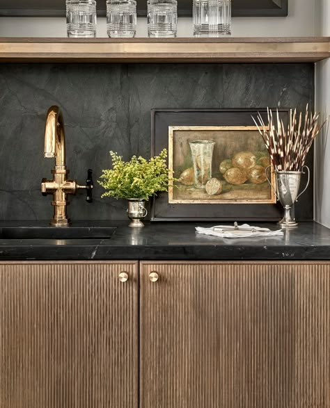 Such a great wet bar with reeded cabinet front! We love the soapstone backsplash and vintage art, as well! | Grand Traditions Homes Bar Layout, Wet Bar Designs, Home Wet Bar, Black Kitchen Cabinets, Bar Designs, Butlers Pantry, White Marble Countertops, Wet Bars, Contemporary Kitchen Design