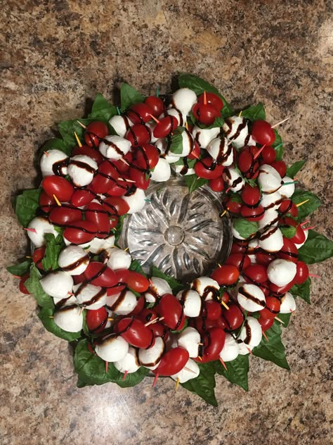 Basil leaves line the dish  Fresh mozzarella balls, basil leaves and grape tomatoes on tooth picks in the shape of a wreath  Drizzle Balsamic Glaze, enjoy Candy Cane Tomato Mozzarella, Tomato And Mozzarella Candy Cane, Caprese Candy Cane Appetizer, Tomato Mozzarella Christmas Wreath, Caprese Christmas Tree Appetizer, Mozzarella Tomato Basil Candy Cane, Caprese Christmas, Healthy Buffet, Mini Mozzarella Balls