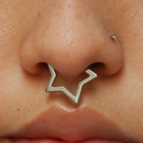 This star titanium septum ring is a stylish and trendy piece of jewelry. It boasts a unique star-shaped design that adds a touch of charm and personality to your look.Crafted from ASTM F-136 titanium, known for its durability and hypoallergenic properties, this ring is suitable for individuals with sensitive skin. Star Bridge Piercing, Star Septum Ring, Star Septum Piercing, Piercings Female, Cool Septum Jewelry, Unique Septum Jewelry, Star Septum, Piercings Men, Gold Septum Piercing