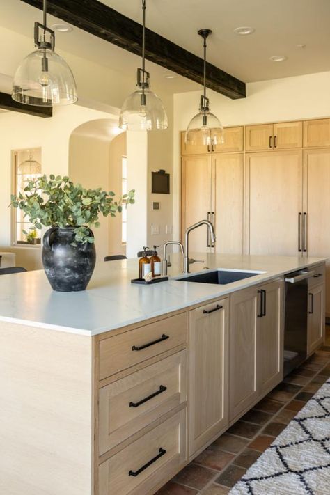 The open plan kitchen exudes warmth with its light-colored wood cabinets and creamy walls. For a pop of contrast, an exposed beam on the ceiling is stained dark brown. Column Kitchen, Scottsdale Home, Stained Kitchen Cabinets, Neutral Contemporary, Wood Column, Fall Front Porch Ideas, Hgtv Designers, Light Colored Wood, Hgtv Dream Home