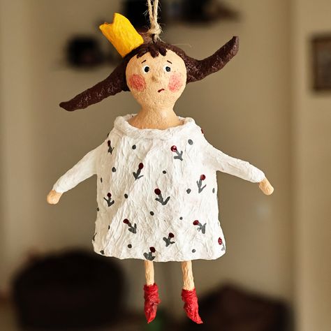 Always doing mischief, looking for adventures and forgetting her duties, little Princess Caprice lives every day to the fullest, enjoying the sun, the natural landscapes and the carefree days of a happy childhood. Made as a whimsical symbol of freedom, this cute papier mache ornament by Anna Nasibyan of Armenia is beautifully painted by hand in a palette of white and red hues, depicting this royal child thinking about what to do next. The ornament also has a jute cord to hang it anywhere. Papier Mache Christmas Ornaments, Paper Mache Christmas Ornaments, Paper Mache Decor, Paper Mache Ornaments, Paper Mache Art Sculpture, Papier Mache Doll, Paper Mache Christmas, Paper Mache Dolls, Symbol Of Freedom